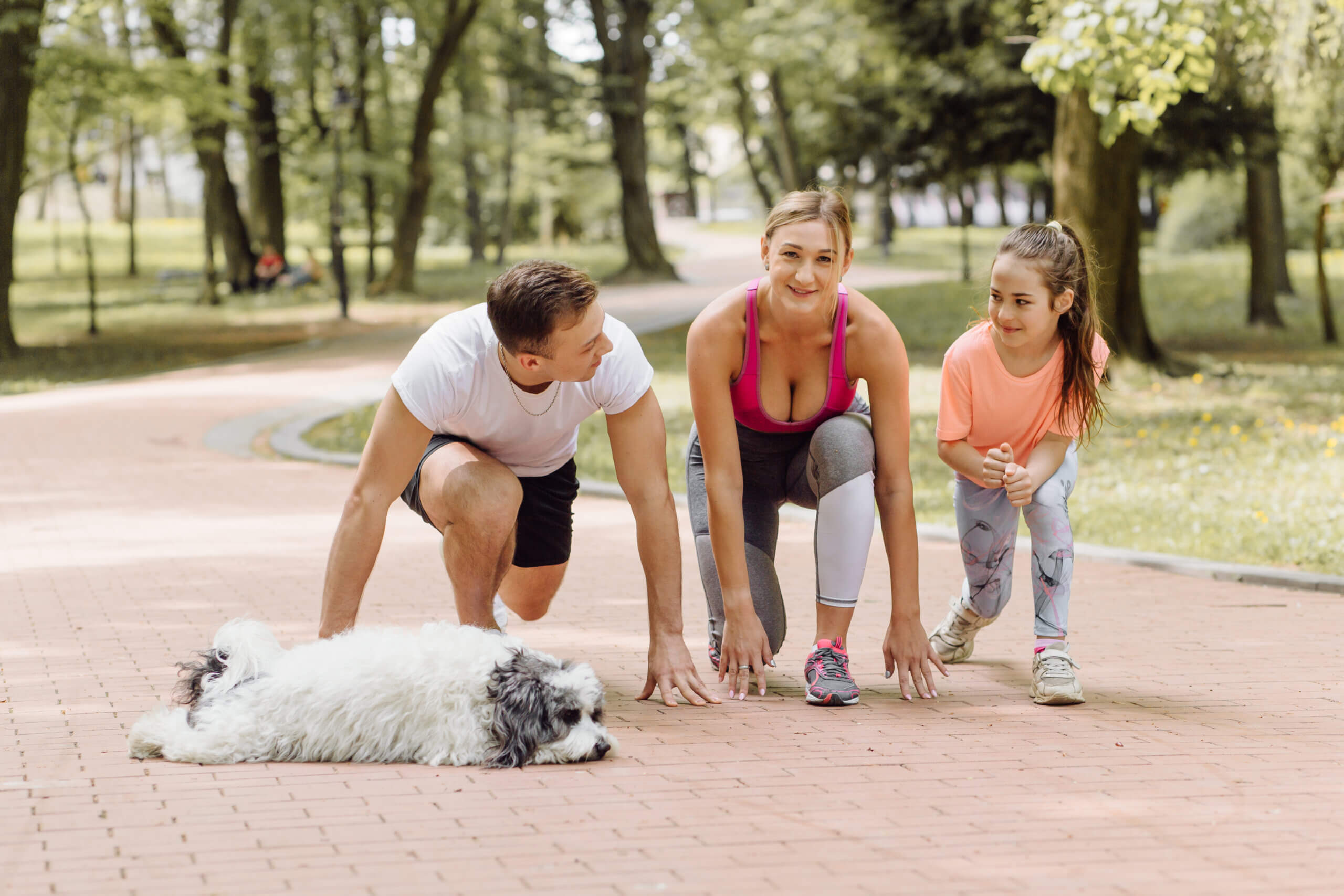 woman man little girl is going running with their dog park scaled